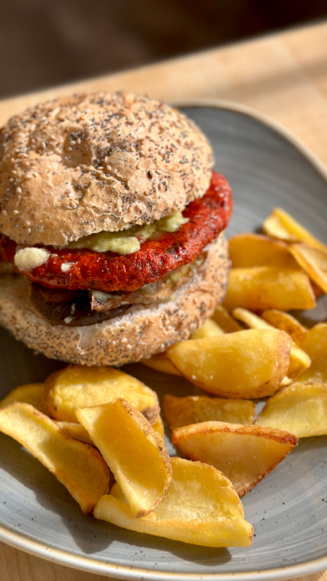 VEGGIE BURGER (VEGANO 🌱): Burger di ceci e rapa rossa, crema di avocado, pesto di mandorla e funghi galletti, servito con patate fritte con la buccia e pane ai cereali